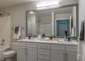 Thumbnail 15 of 53 - A bathroom with a white toilet, a white sink, and a white bathtub.