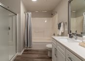 Thumbnail 14 of 53 - A white bathroom with a toilet, sink, and shower.