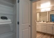 Thumbnail 13 of 53 - A bathroom with a white door and a mirror above a sink.