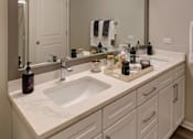 Thumbnail 12 of 53 - A bathroom with a white sink and a mirror.