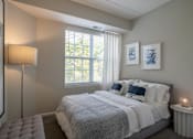 Thumbnail 11 of 53 - A bedroom with a large bed and a window with blinds.