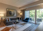 Thumbnail 2 of 53 - A living room with a grey couch, a blue chair, and a coffee table.