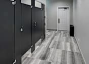 Thumbnail 31 of 53 - A hallway with black doors and a white door at the end.