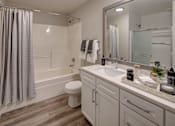 Thumbnail 10 of 53 - A bathroom with a white toilet, a white sink, and a white bathtub with a shower curtain.