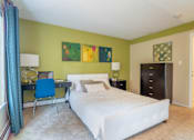 Thumbnail 30 of 31 - A bedroom with a white bed and a blue chair.