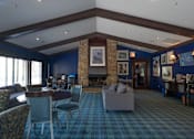 Thumbnail 15 of 31 - A living room with a fireplace and a blue carpet.