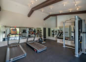 Thumbnail 19 of 31 - A gym with treadmills, weights, and mirrors.