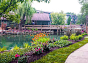 Thumbnail 11 of 31 - A garden with a pond and a bridge.