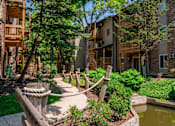 Thumbnail 3 of 31 - A small pond is in the front yard of a building.