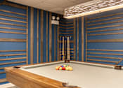 Thumbnail 43 of 62 - A pool table with a cue stick and balls on it.