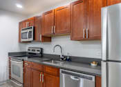 Thumbnail 59 of 62 - A kitchen with a stainless steel refrigerator, microwave, oven, and sink.