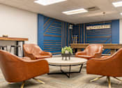 Thumbnail 47 of 62 - A conference room with a blue accent wall and brown leather chairs.