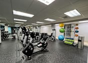 Thumbnail 38 of 62 - A gym with a variety of equipment including a treadmill, stationary bike, and weight machines.