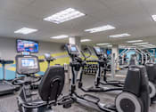 Thumbnail 40 of 62 - A gym with treadmills and elliptical machines.