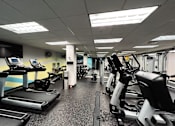 Thumbnail 36 of 62 - A gym with treadmills, exercise bikes, and other equipment.
