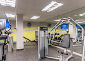 Thumbnail 39 of 62 - A gym with a variety of equipment including a leg press machine.