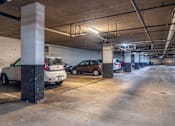 Thumbnail 30 of 62 - A parking garage with two cars parked.