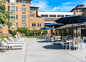 Thumbnail 25 of 62 - A sunny day at the outdoor seating area of a building.