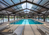 Thumbnail 19 of 62 - A large indoor swimming pool with a glass ceiling.