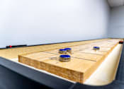 Thumbnail 44 of 62 - A shuffleboard table with blue pucks on it.