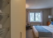 Thumbnail 10 of 62 - A bedroom with a bed, nightstand, and window with curtains.