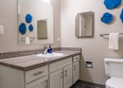 Thumbnail 14 of 62 - A bathroom with a white toilet, a sink, and a mirror.