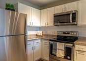 Thumbnail 6 of 62 - A kitchen with a stainless steel refrigerator, microwave, and oven.
