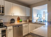 Thumbnail 7 of 62 - A kitchen with white cabinets and stainless steel appliances.