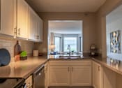 Thumbnail 8 of 62 - A kitchen with white cabinets and a granite countertop.