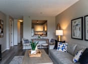 Thumbnail 5 of 62 - A living room with a grey couch and a wooden coffee table.