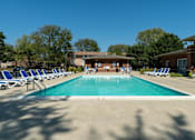 Thumbnail 37 of 43 - A swimming pool surrounded by chairs and trees.