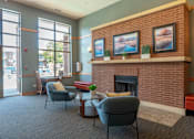 Thumbnail 34 of 43 - A living room with a fireplace and two chairs.