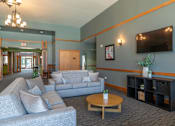 Thumbnail 35 of 43 - A living room with grey couches and a wooden coffee table.