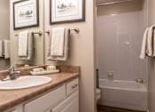 Thumbnail 21 of 43 - A bathroom with a sink, mirror, and towel rack.