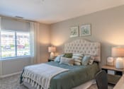 Thumbnail 29 of 43 - A bedroom with a large bed and a window with curtains.