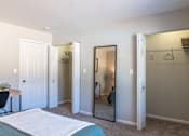 Thumbnail 31 of 43 - A bedroom with a bed, desk, and closet.