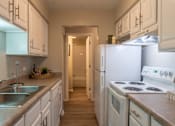 Thumbnail 10 of 43 - A kitchen with white appliances and cabinets.