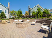 Thumbnail 35 of 73 - A backyard with a fire pit and seating area.