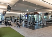 Thumbnail 48 of 73 - A gym with a variety of equipment including treadmills, weights, and exercise machines.