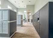 Thumbnail 57 of 73 - A hallway with a series of lockers on the right and a door at the end.