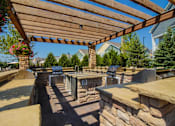 Thumbnail 30 of 73 - A patio with a stone wall and a wooden pergola.