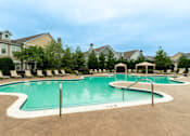 Thumbnail 27 of 73 - A large outdoor swimming pool surrounded by lounge chairs and umbrellas.
