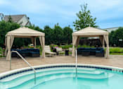 Thumbnail 25 of 73 - A pool with a canopy and chairs around it.