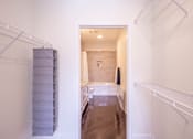 Thumbnail 7 of 73 - A long hallway with a white wall and a white door.