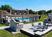Thumbnail 17 of 25 - A patio with a table and chairs overlooking a pool.