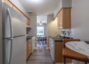 Thumbnail 1 of 25 - A kitchen with a refrigerator, table and chairs.