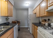 Thumbnail 2 of 25 - A kitchen with wooden cabinets and a white refrigerator.