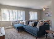 Thumbnail 5 of 25 - A living room with a blue couch and a television.