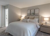 Thumbnail 11 of 25 - A bedroom with a large bed and two lamps.