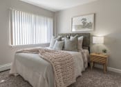 Thumbnail 6 of 25 - A bedroom with a large bed covered in a white blanket and pillows.
